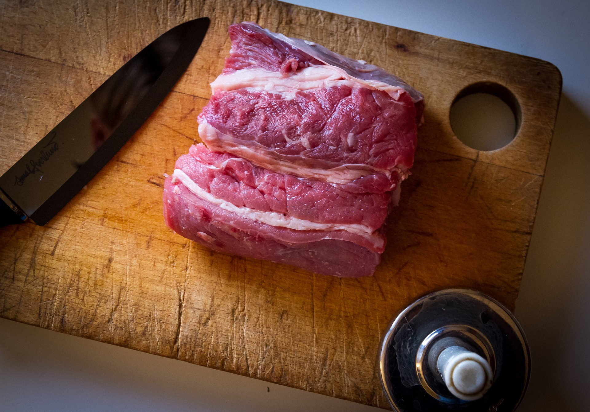 Stück rohes Fleisch auf Schneidebrett